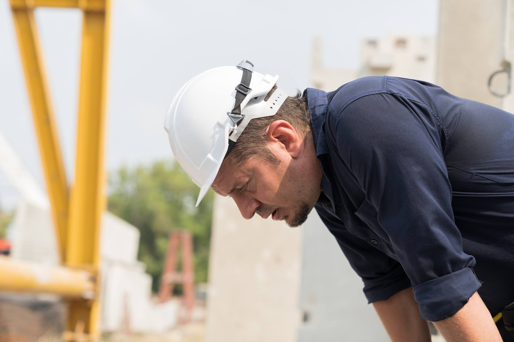 Hombre que trabaja en construcción con claros síntomas de fatiga o cansancio crónico.