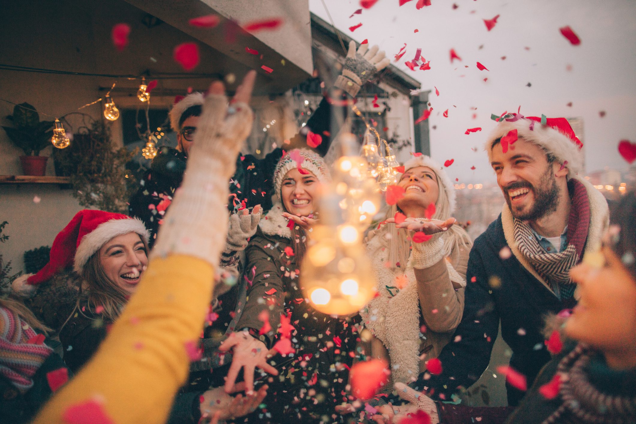 Grupo de personas, con gorros de papa noel, disfrutando de la Navidad.