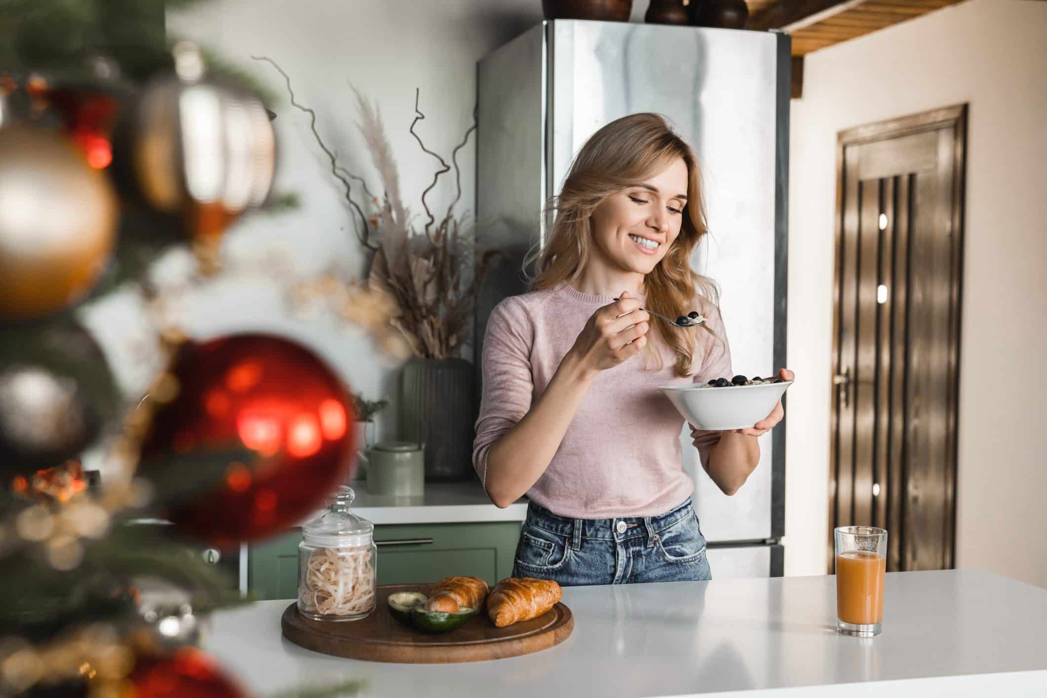 Mujer retomando hábitos saludables después de las fiestas, intentando desayunar de forma equilibrada en casa